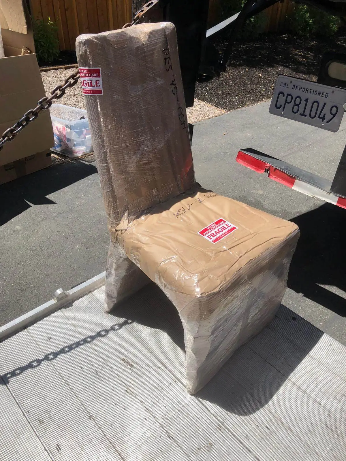 A dining chair wrapped and taped, waiting at the loading ramp.